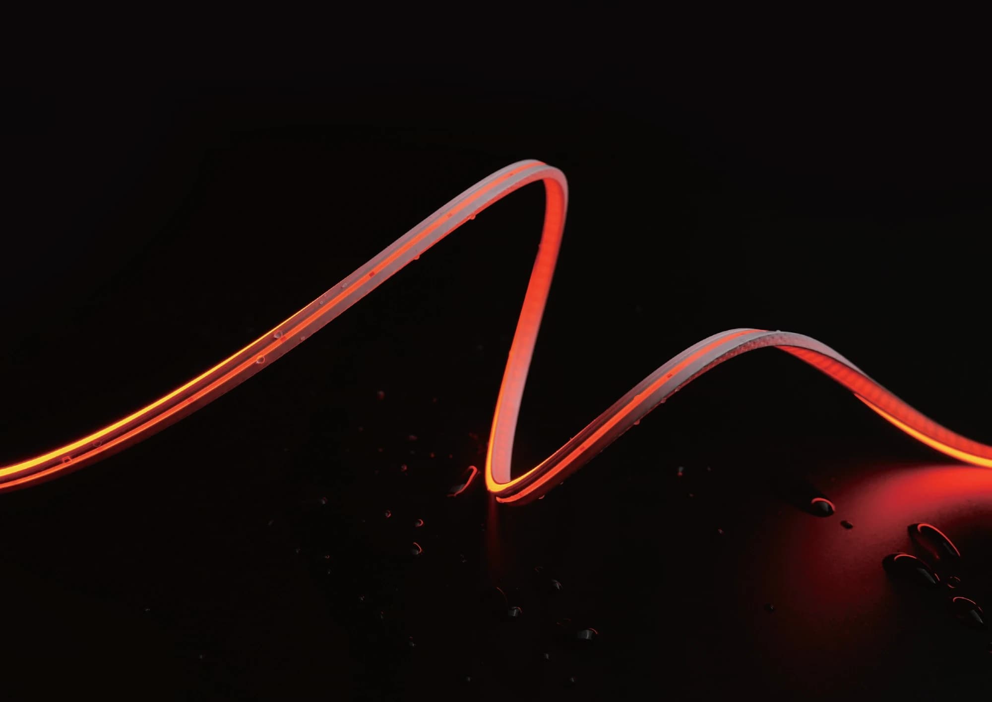 A flexible strip curved into a wave, lit end to end without dark spots