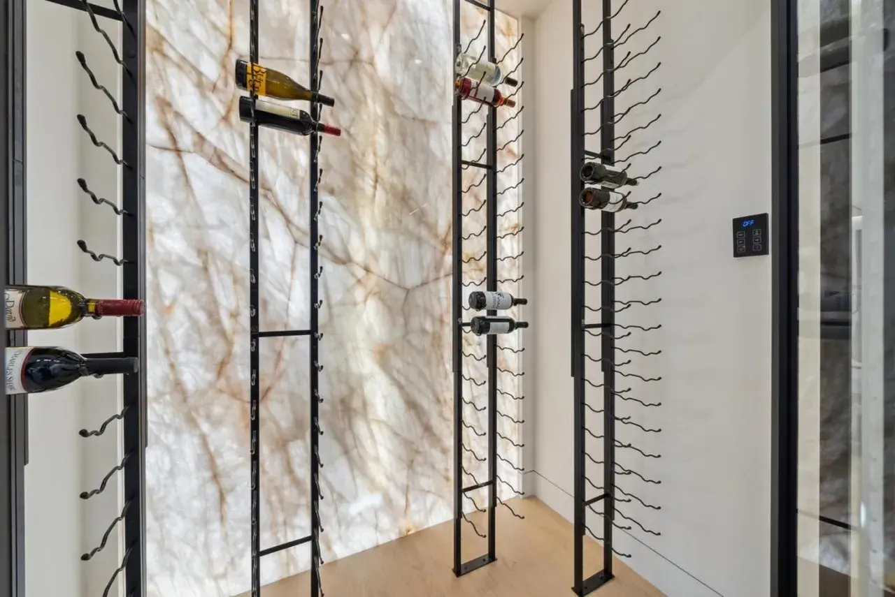 Wine display racked against a backlit stone panel