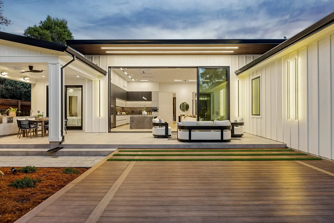 Covered outdoor room at dusk with a lit ceiling
