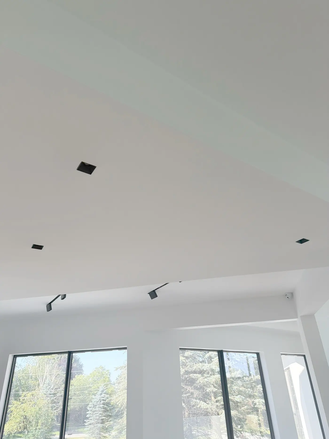 Track heads recessed into the ceiling above tall windows