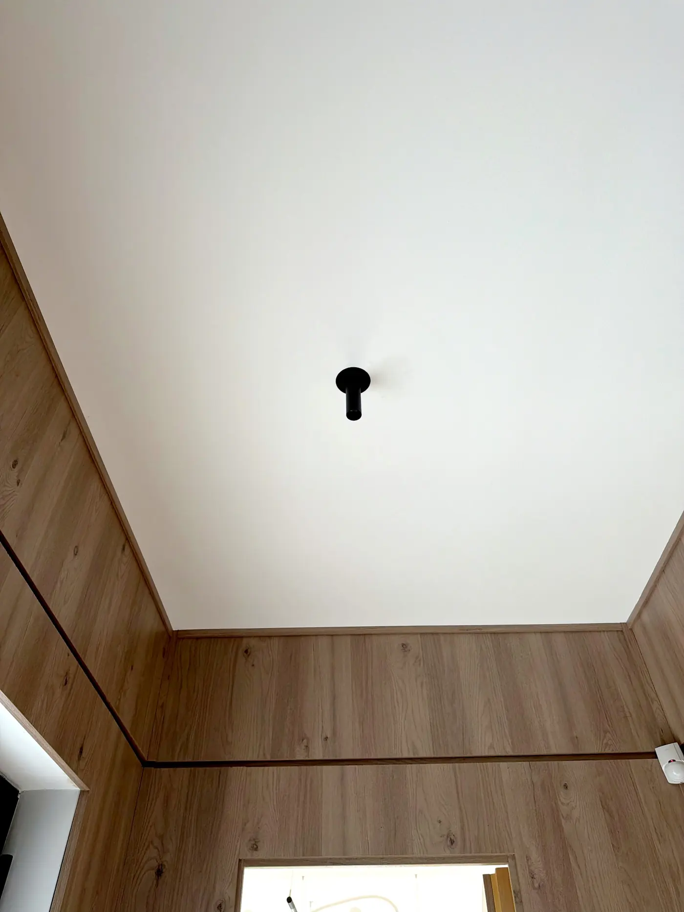A single recessed spot against a wood lined wall