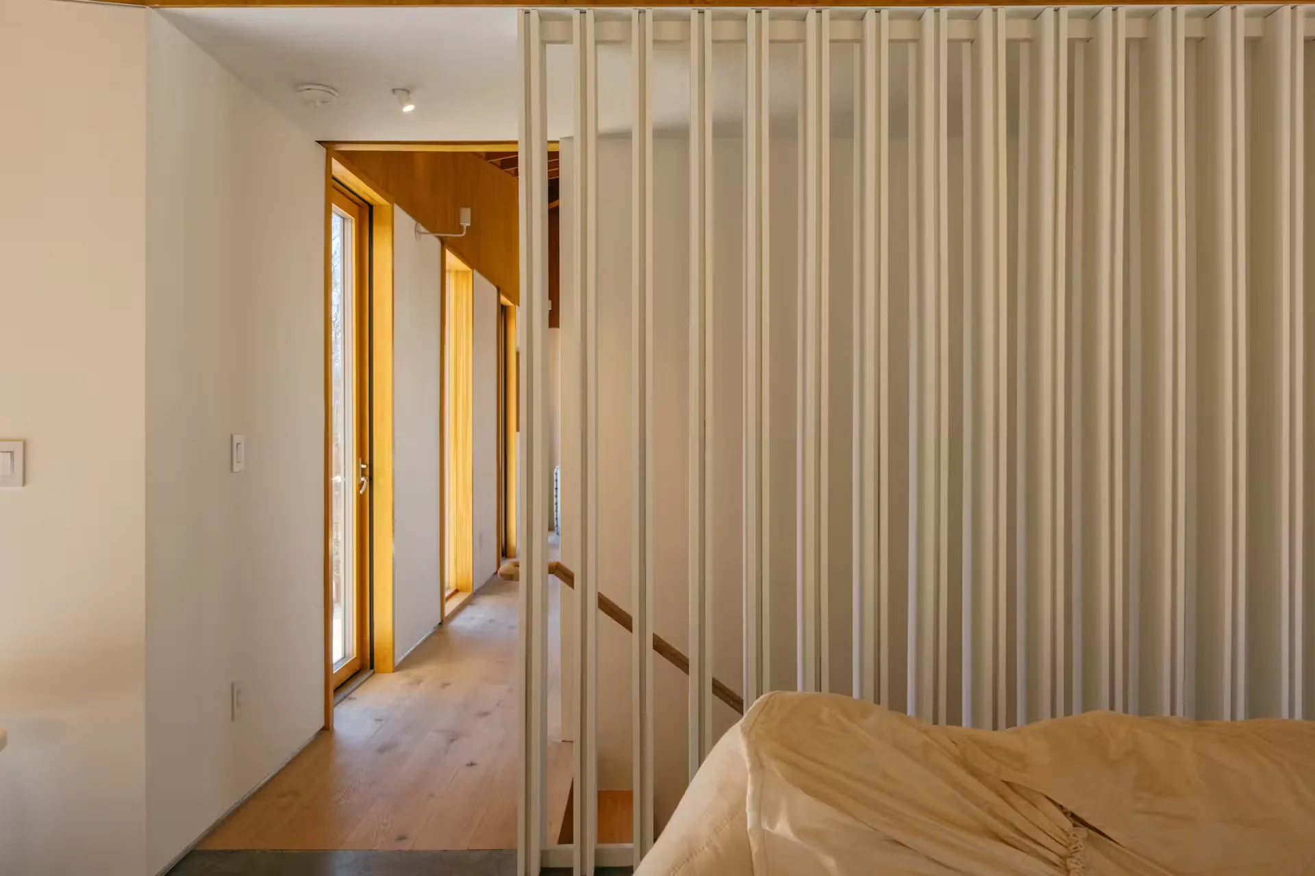 Corridor beside a floor to ceiling slatted timber screen