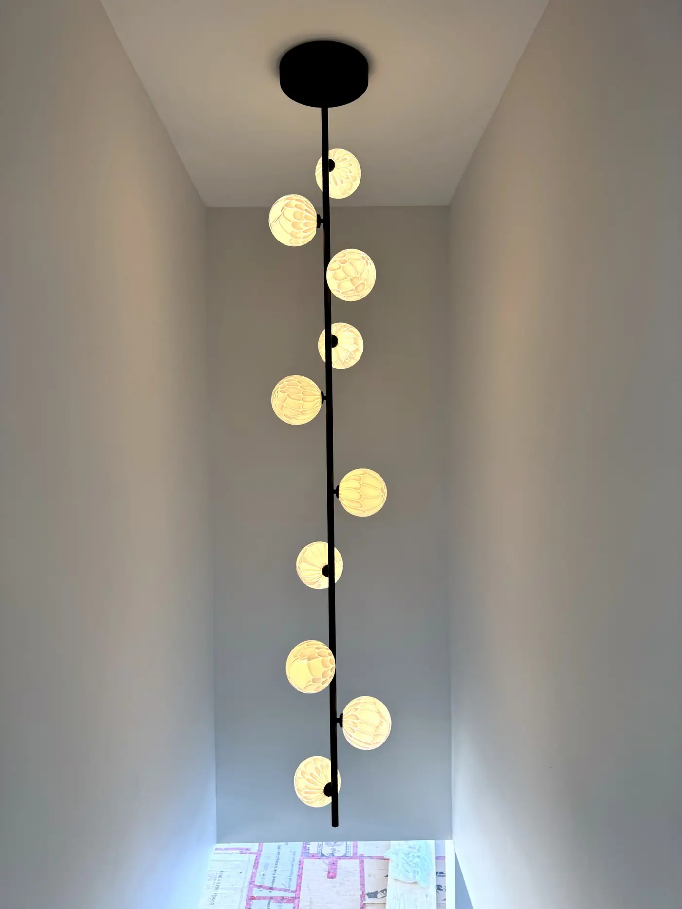 Cascade of globe pendants dropping through the stairwell