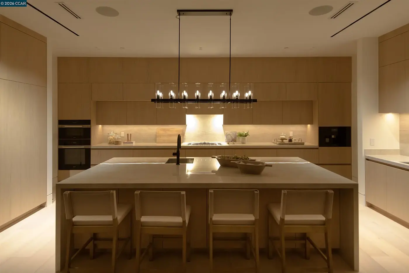 Kitchen with a linear pendant over the island and a lit under cabinet run