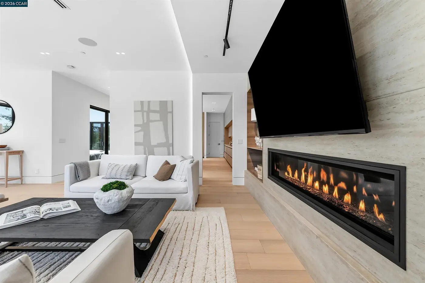 Living room with a long linear fireplace under a stone chimney