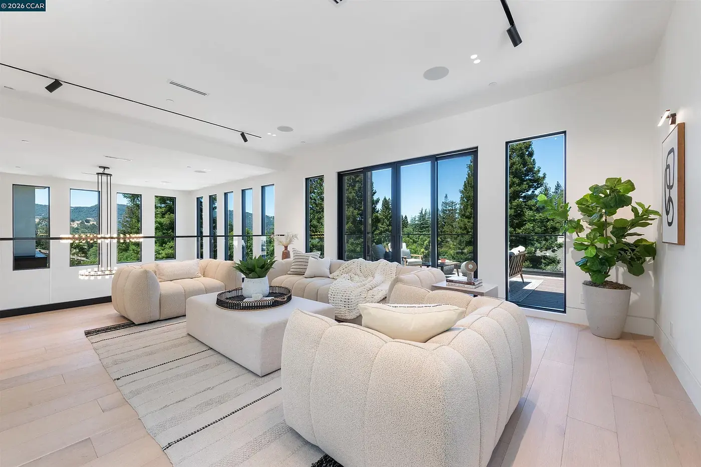 Living room with white seating against tall windows